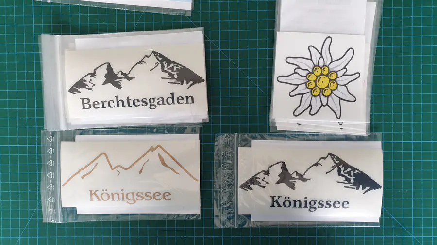 Vier regionale Bergmotiv-Aufkleber auf einer Schneidematte